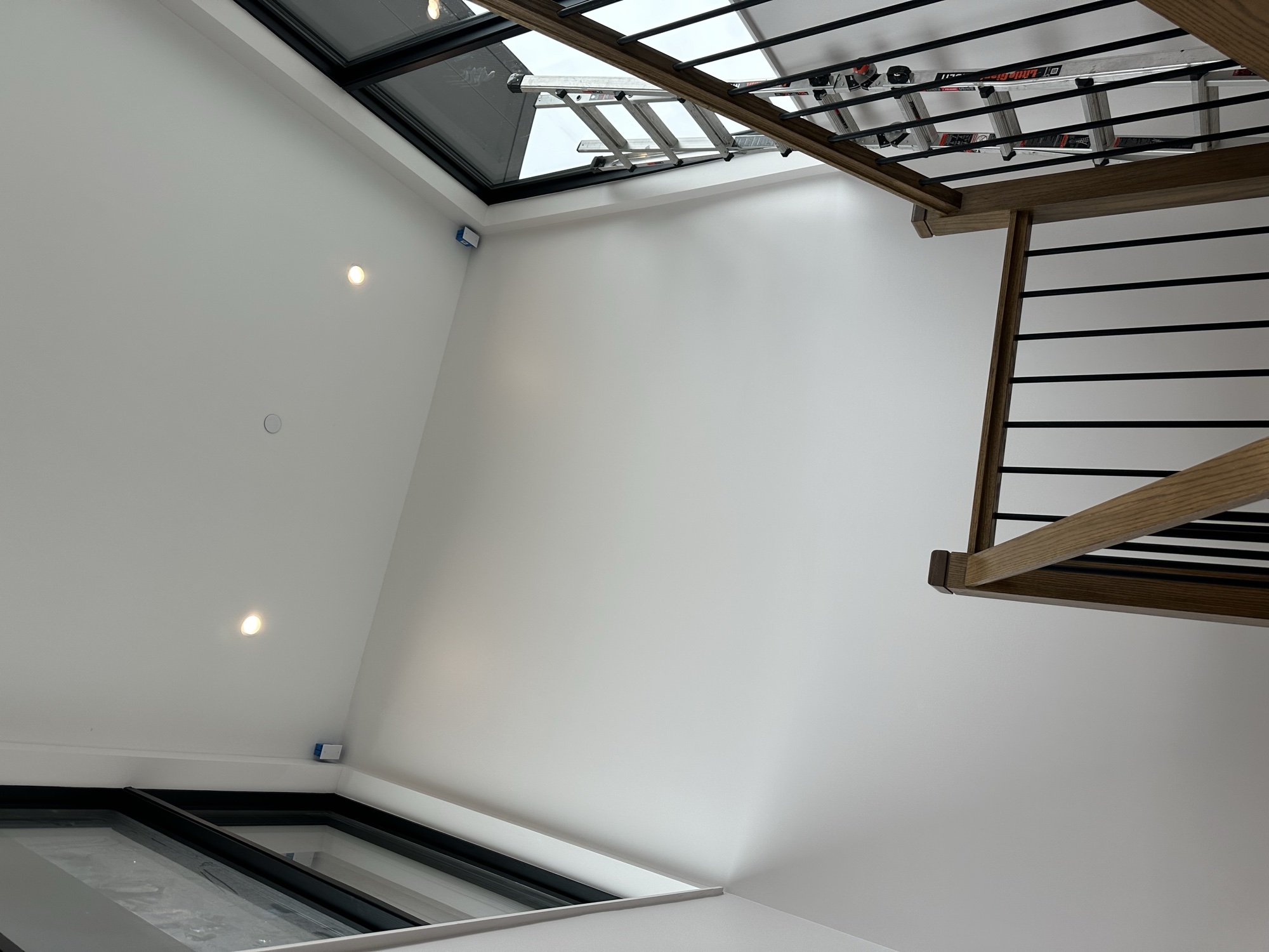 Modern staircase with clean white walls and skylights