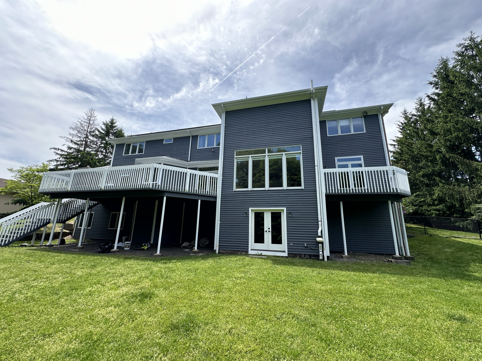 Large home rear view with stained deck by J&B Painting