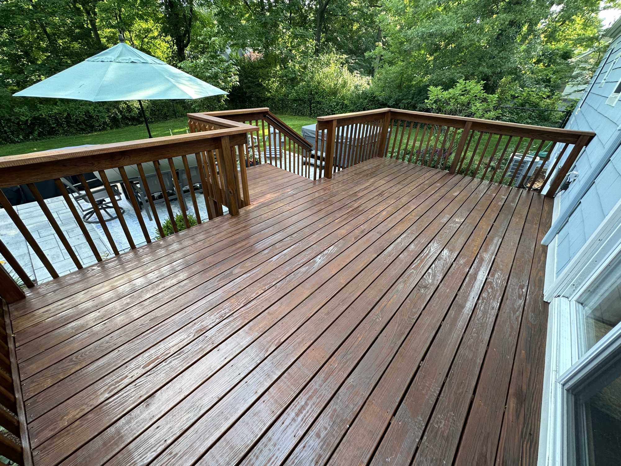 Large stained deck with patio umbrella, lifestyle view