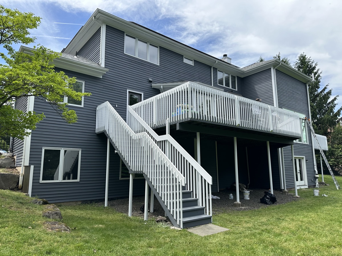 Gray home with white painted deck stairs and railings