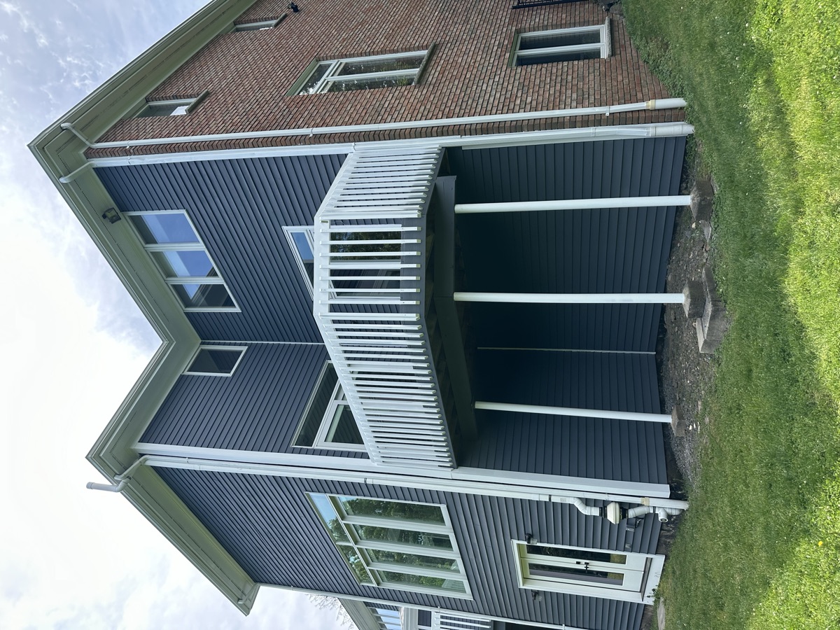 Dark gray home with white painted deck and railings