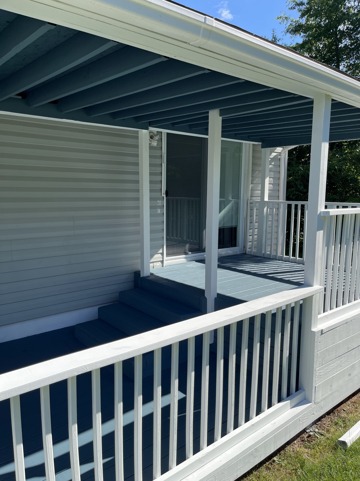 Blue painted covered porch with white railings