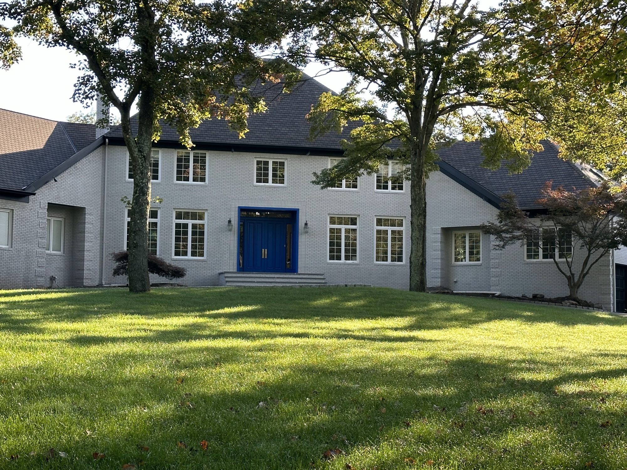 Gray painted brick estate with blue front door