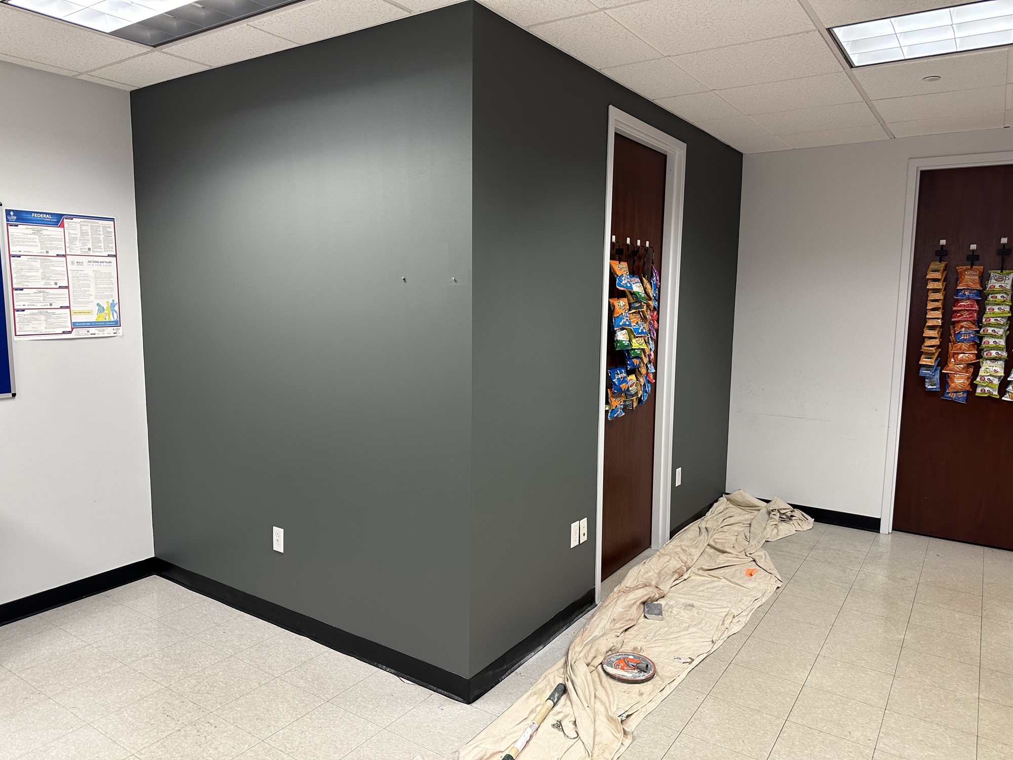 Commercial break room with dark accent wall painting
