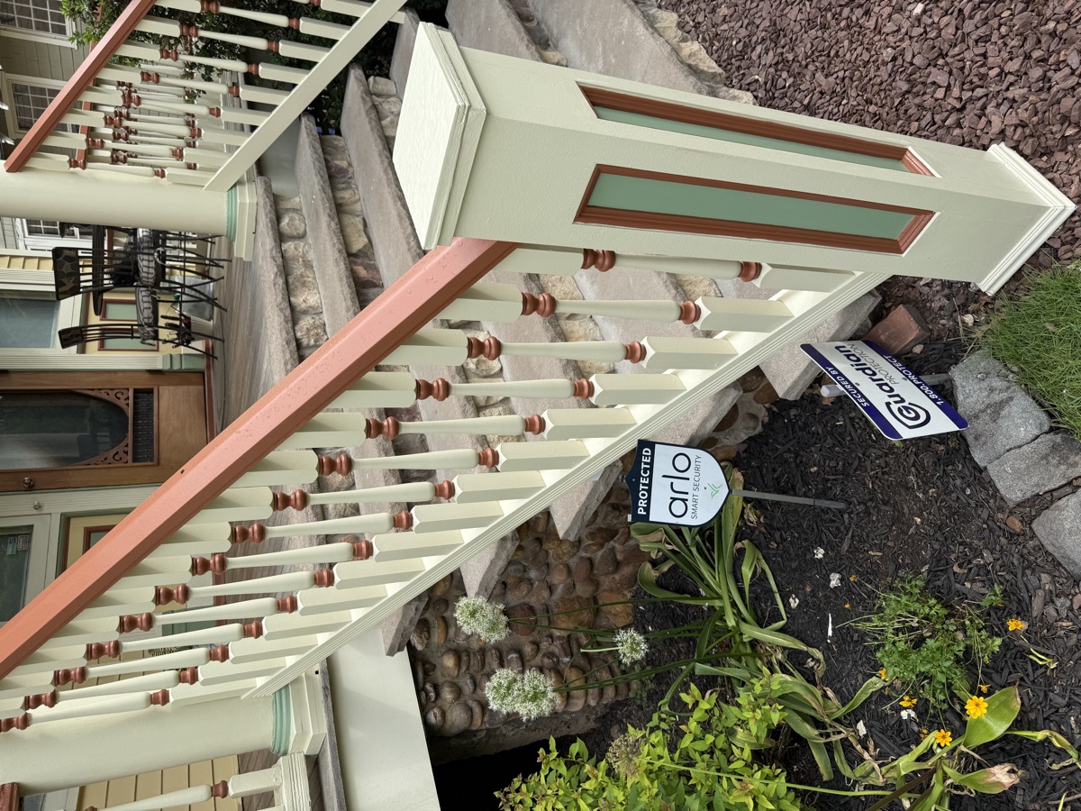 Craftsman porch restoration with painted railings and stone pillars