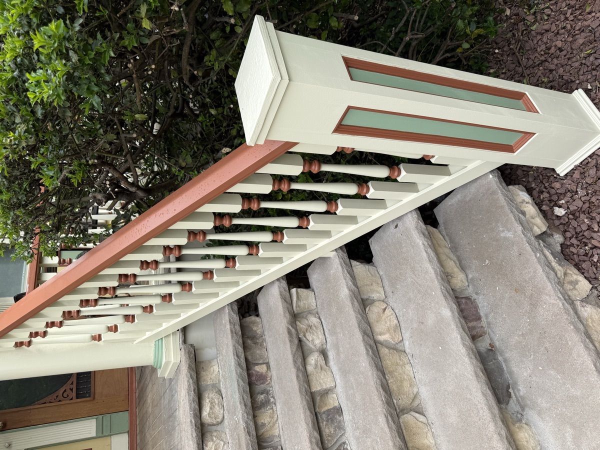 Restored porch railing detail with stone column